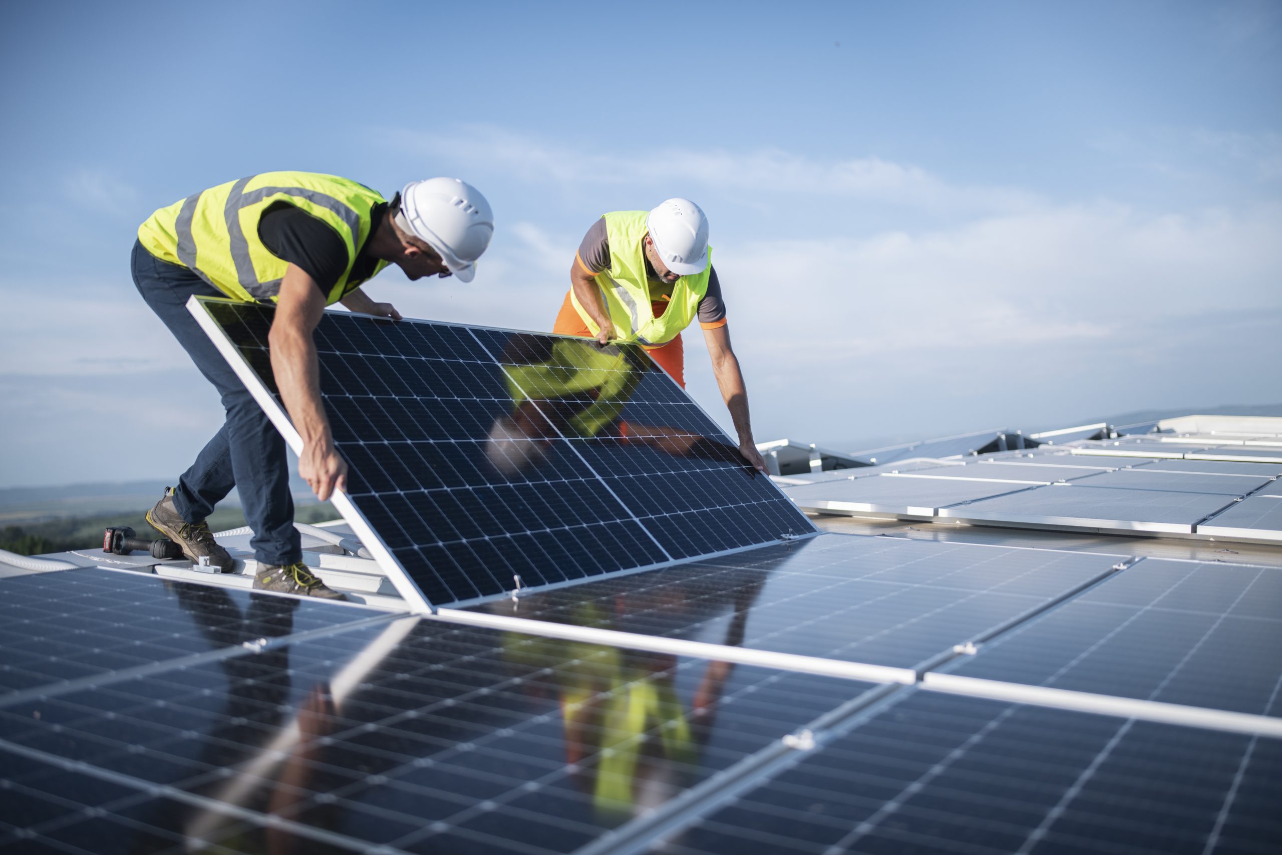 solar energy panels being installed by two construction workers